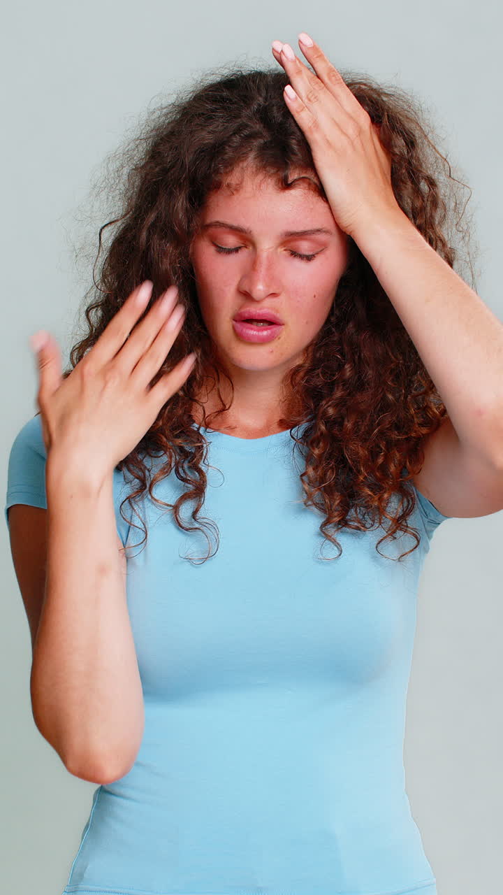 Woman suffering headache stress holding head closing eyes painful tired exhausted facial reaction