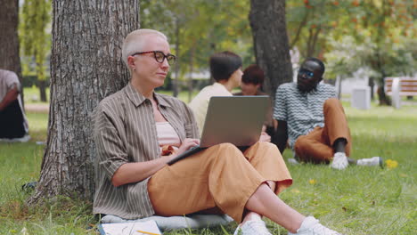 Porträt-Einer-Kurzhaarigen-Kaukasischen-Frau-Mit-Laptop-Im-Park