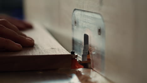 machinist at work performing tasks on wood shaper, close up