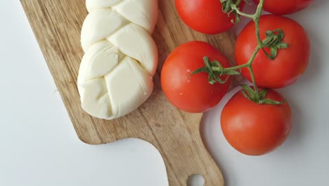 tomates frescos y queso mozzarella en una tabla de cortar