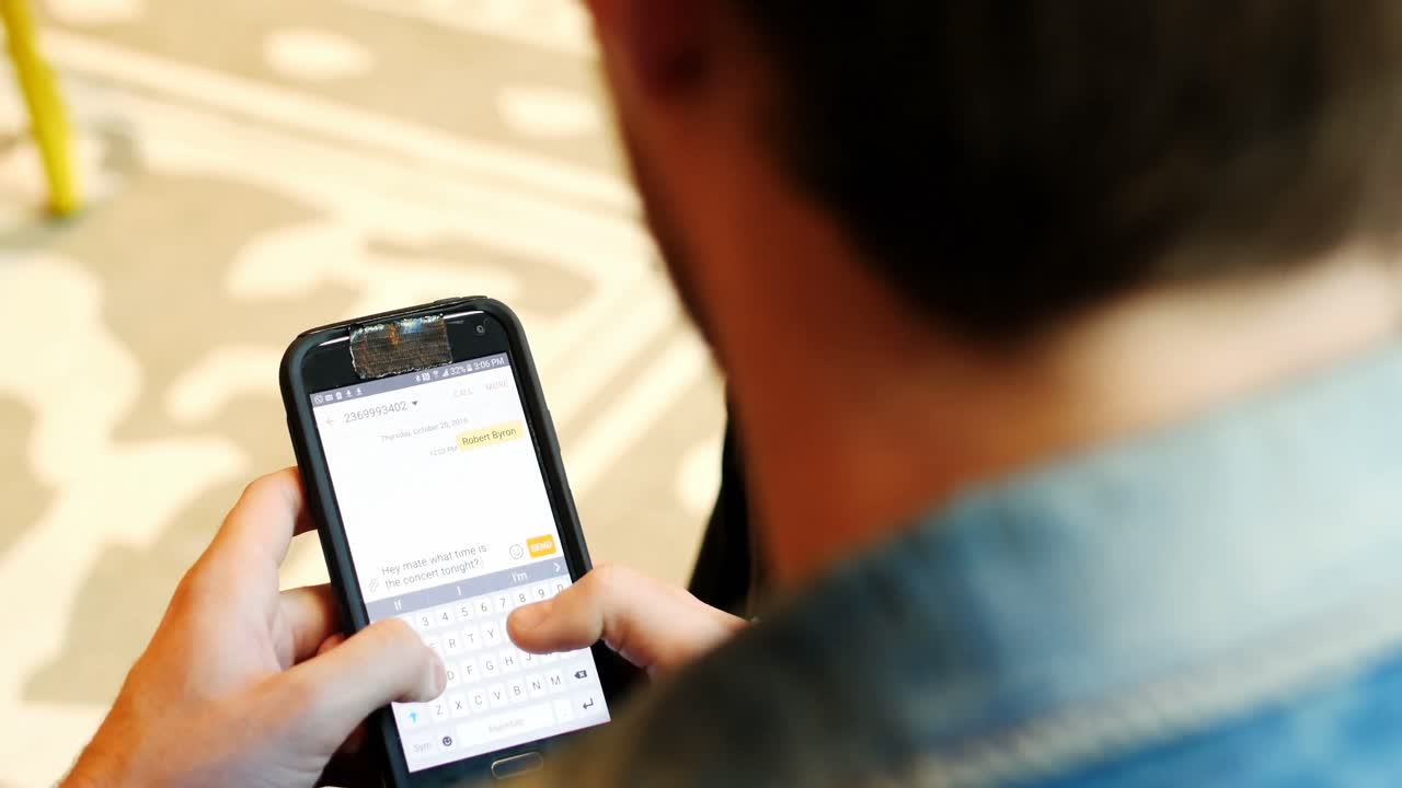 vista trasera de un hombre usando un teléfono móvil