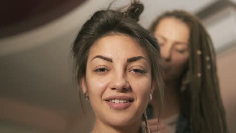 Close-Up-view-of-a-young-smiling-hipster-woman-in-the-hair-salon.-The-hairdresser-doing-dreads-for-a-young-woman.-Slow-Motion-shot