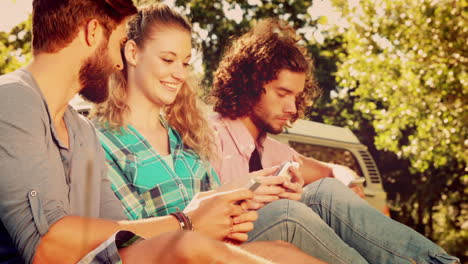 hipsters usando sus teléfonos inteligentes en el parque