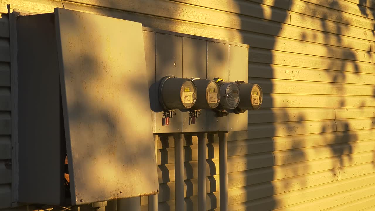나무 그림자가 있는 다중 주거 타운하우스 개발 끝에 있는 하이드로 패널 상자 및 원형 미터