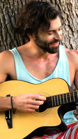 woman taking a picture of a man playing guitar