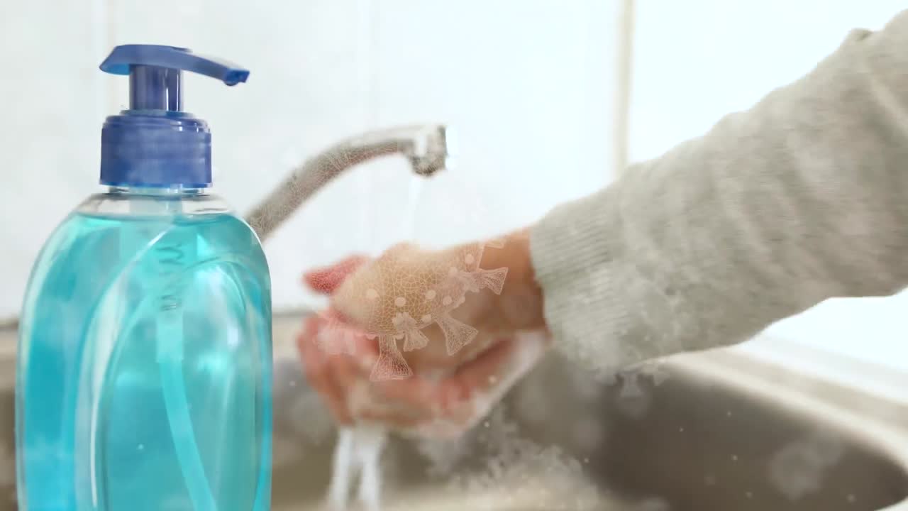 animación de células de covid 19 sobre una persona lavando las manos