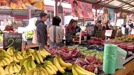 personas comprando frutas en un puesto de mercado