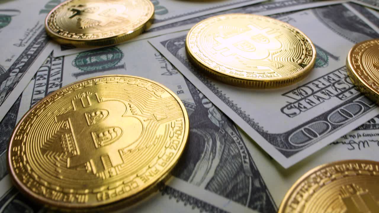 Gold Bit Coin BTC coins and dollar bills.