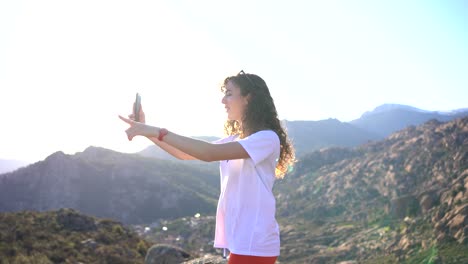 mujer alegre grabando video y mostrando los alrededores en las tierras altas
