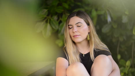 una hermosa chica rubia piensa en un parque