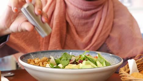 woman eating a delicious salad at a restaurant