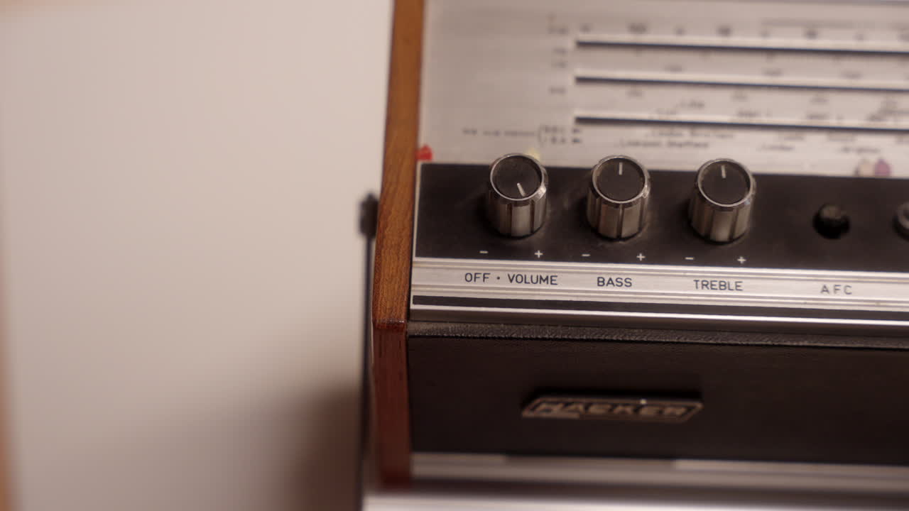 오래된 빈티지 라디오에서 볼륨을 조절하는 사람