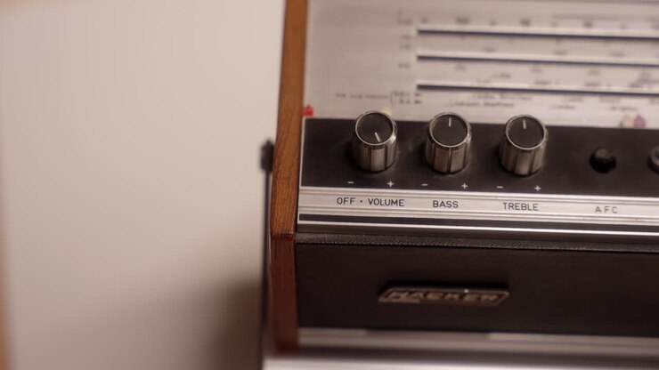 Una persona che regola il volume su una vecchia radio vintage.
