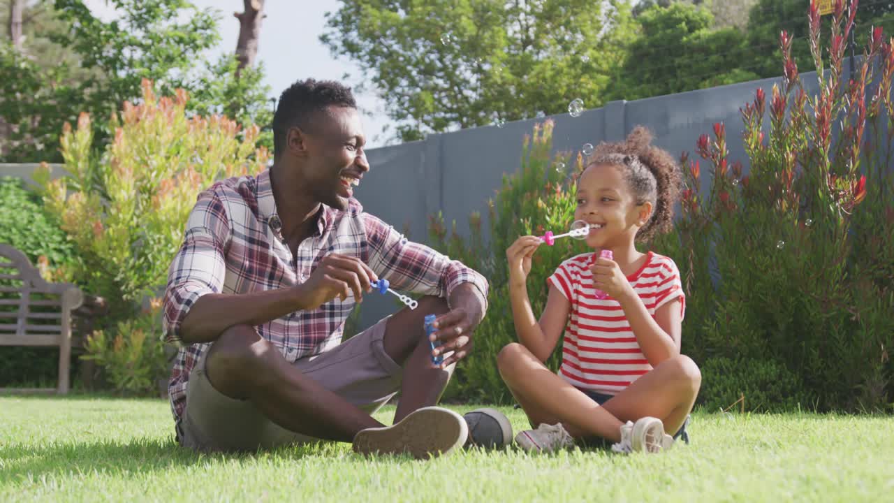 African american father and daughter playing outside