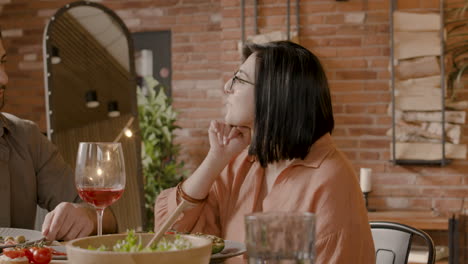 un grupo de tres amigos brindan con sus copas en una cena 2