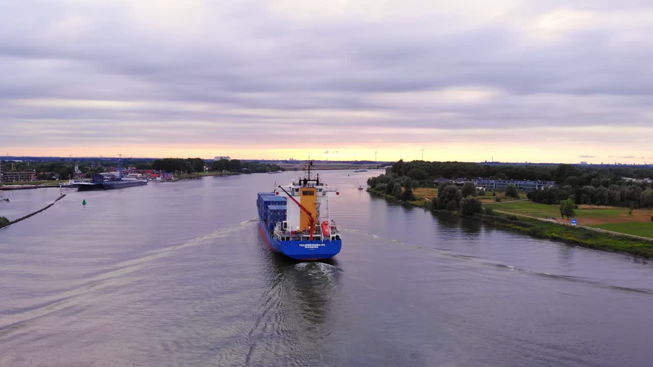 toma trasera del barco portacontenedores panda con viento de cola que cruza el río oude maas, países bajos
