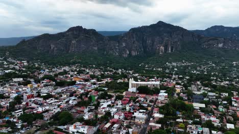 Volando-Sobre-El-Paisaje-Urbano-De-Tepoztlán,-Morelos,-Día-Nublado-En-México---Vista-Aérea