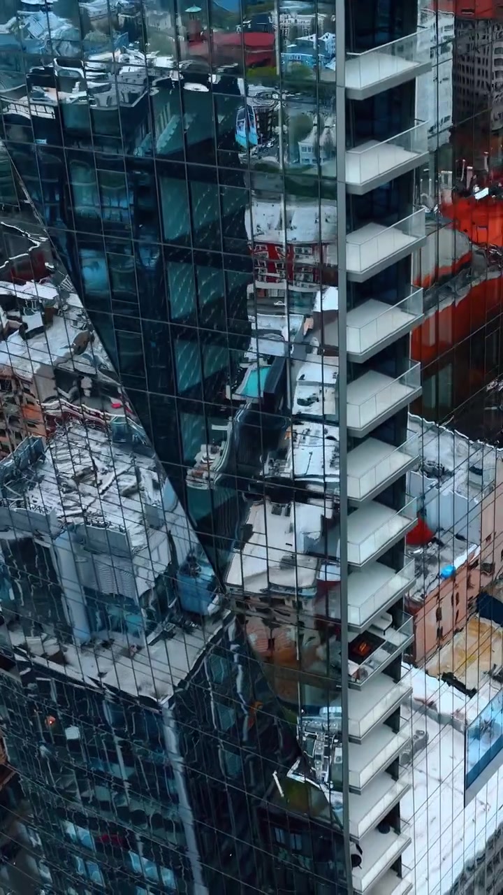 Descida ao longo da fachada espelhada de um edifício alto. Vista de uma rua em Portland, Oregon, EUA, do alto. Vídeo vertical.