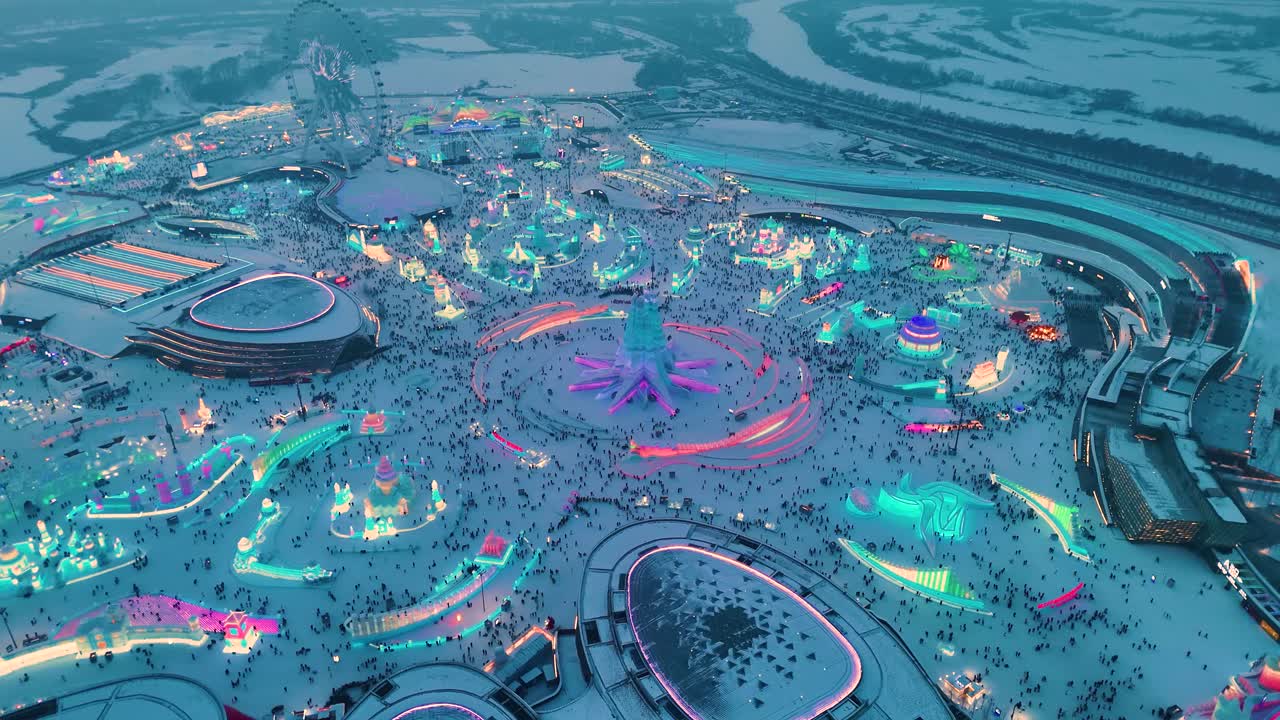 Drone shot of the Harbin Ice Festival, China. Sculptures, fun rides, and people having a good time during sunset.