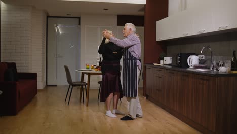 Senior-couple-in-love-dancing.-Romantic-evening-supper-with-wine-and-candles-celebrating-anniversary