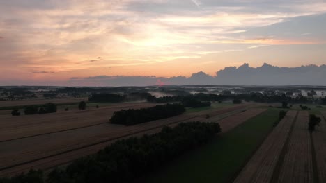 aerial of sunset above agricultural land with remote rural village slow living off grid concept