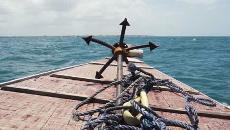 grappling anchor and rope on bow deck of seaborne wooden boat