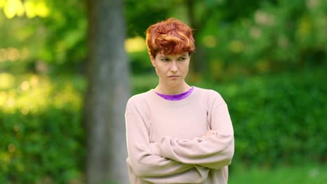 serious woman with crossed arms in a park