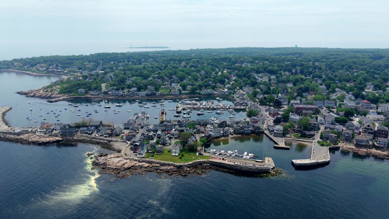 Puerto de Rockport y costa de granito con barcos anclados y casas clásicas de Nueva Inglaterra, capturando el carácter atemporal de un pueblo pesquero de Massachusetts, movimiento de cámara hacia la izquierda.