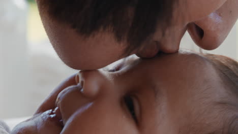 close up mother kissing baby laughing enjoying loving mom nurturing her toddler showing love at home