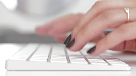 Primer-Plano-De-Una-Mujer-Casada-Escribiendo-En-Un-Teclado,-Manos-De-Una-Mujer-Vista-Desde-Un-Lado-Mientras-Trabaja-En-La-Computadora