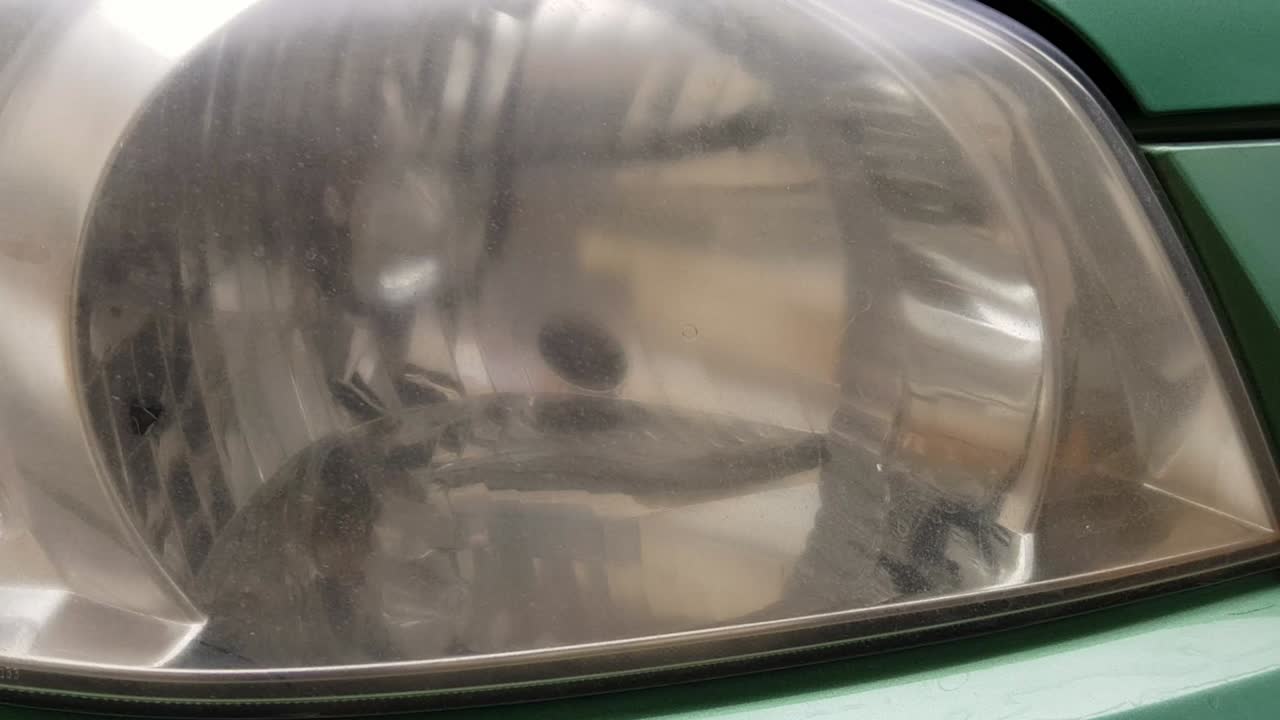 panorámica a cámara lenta en los faros de los coches viejos empañados en el coche verde