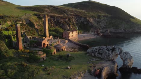 porth wen abandoned coastal derelict brickworks remains golden sunrise countryside bay aerial view slow establishing shot