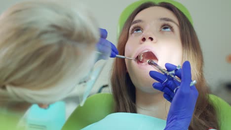 dentista haciendo una inyección anestésica en el diente del paciente. paciente en la silla del dentista