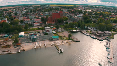 aerial shot of drone flying above blue baltic sea towards the puck city in poland