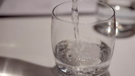 close up shot of water pouring into glass in slow motion