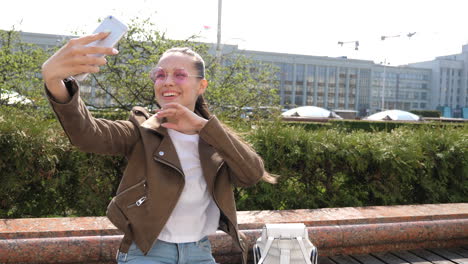 young woman taking a selfie in a city park