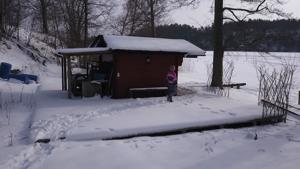 겨울 원더랜드에 혼자 있는 동안 지루함을 느끼며 오두막을 향해 걸어가는 외로운 소녀