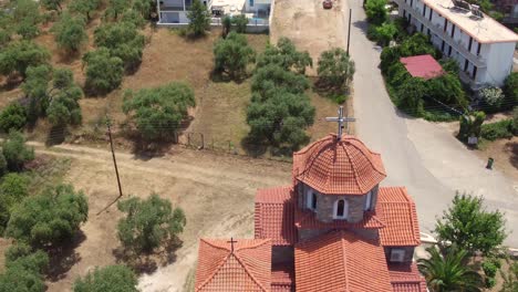 reverse reveal of small greek church to reveal olive tree plantations and mountains on thassos island, greece