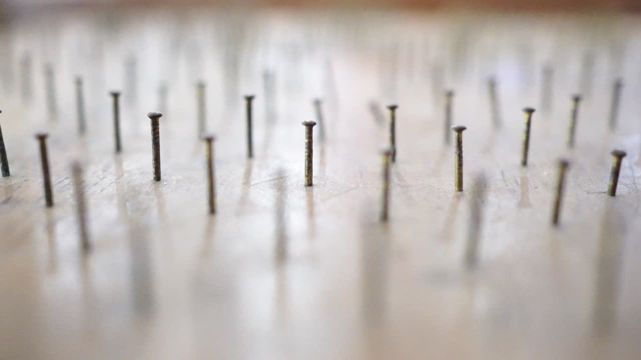 나무로 만든 핀볼 테이블 위에서 유리 구슬이 핀볼테이블 위로 굴러 내려온다.