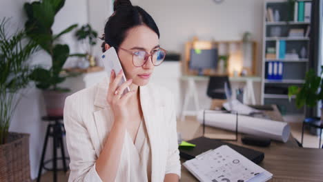 sad woman talks to boss on phone in office