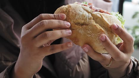 persona comiendo un sándwich