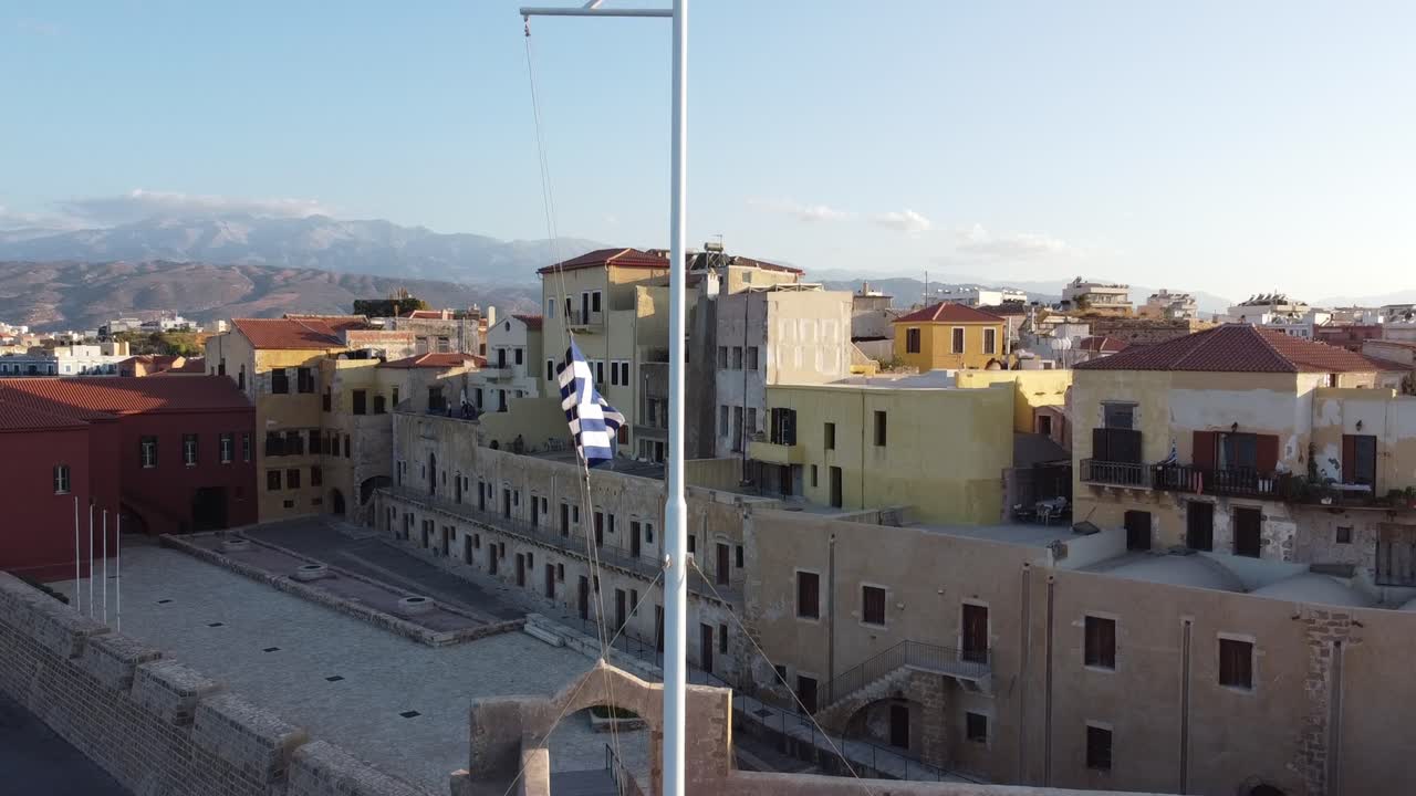 Bandiera nazionale greca che sventola nel porto della città vecchia di Chania, Creta, ripresa drone.