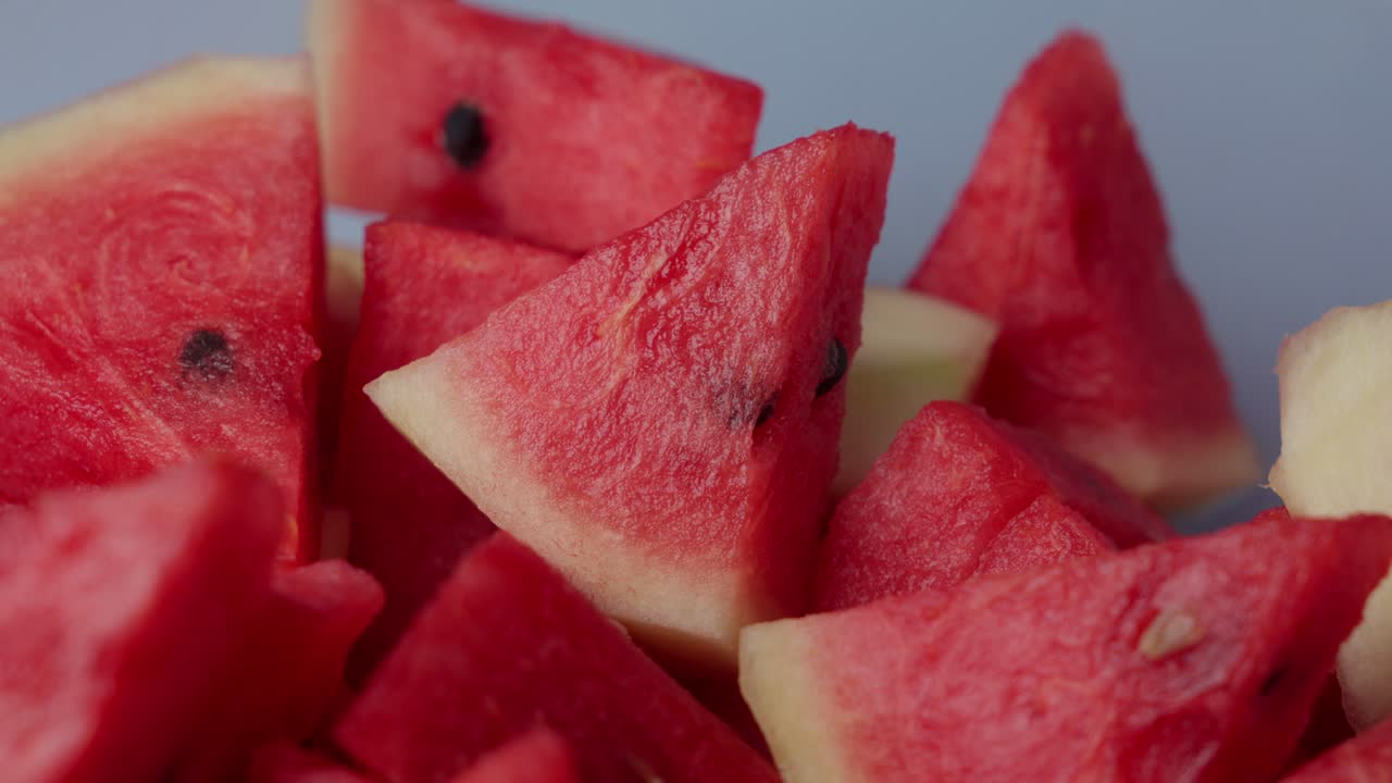 Close-up of hand picking a slice of fresh watermelon