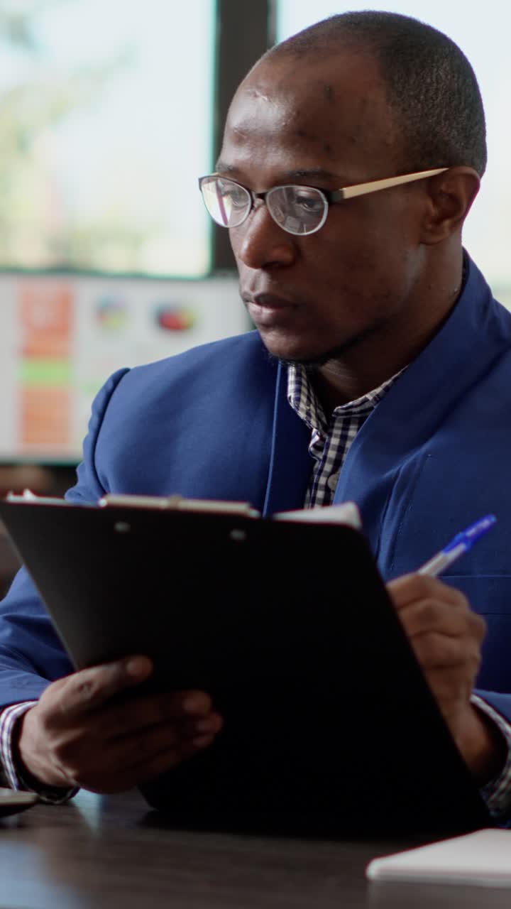 Man writing on a clipboard in an office setting