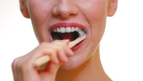 Close-up-of-woman-using-an-organic-wood-toothbrush