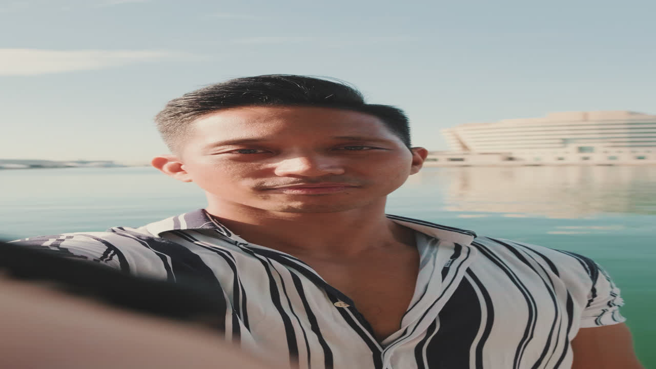 Uomo che si fa un selfie vicino all'acqua