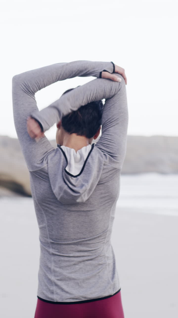 Rear View of Woman Stretching Arms on a Sandy Beach