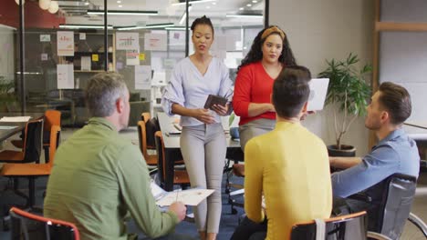 personas con discapacidad felices y diversas personas de negocios discutiendo el trabajo durante una reunión en la oficina