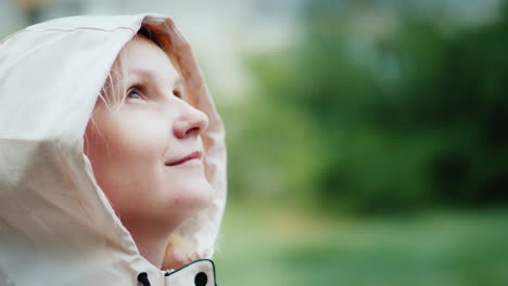 portrait of a young woman enjoying the spring rain looking up hiking and adventure freshness concept