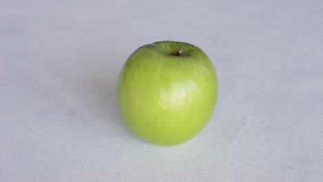 hand puts fresh green apple on the table